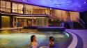 Twee gasten ontspannen in het binnenbad van Thermen Holiday in de avond 