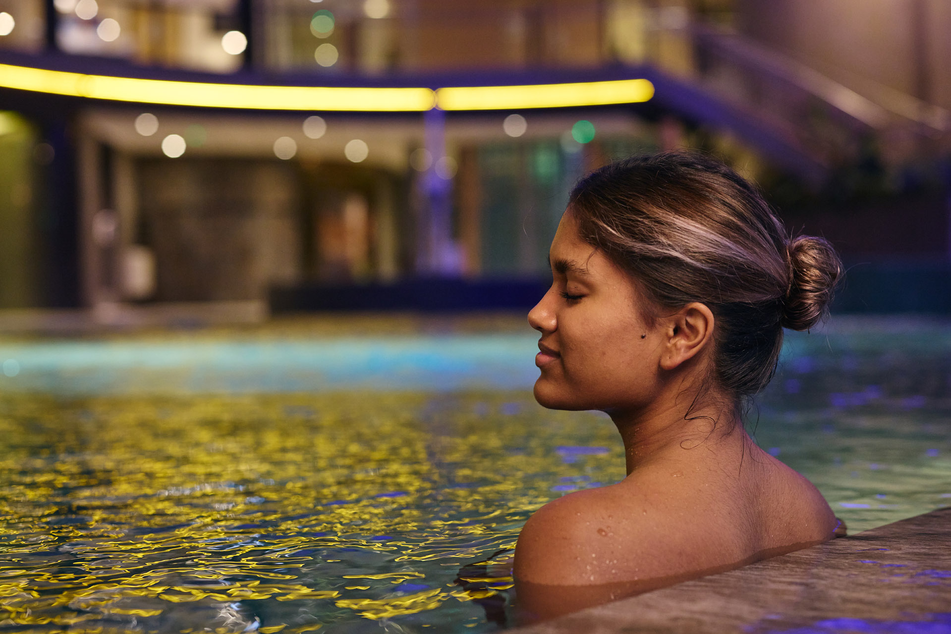 Een vrouw ontspant in het binnenzwembad van Thermen Holiday 